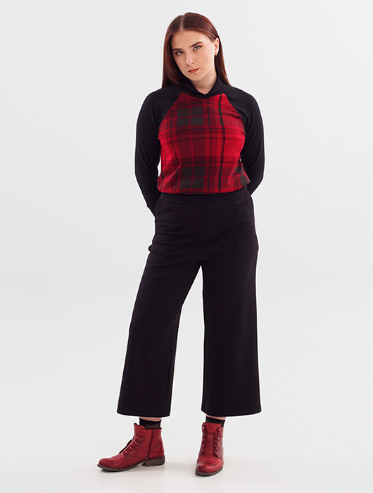 Chandail rouge et noir et pantalon noir.